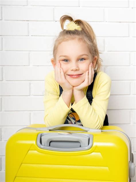 Happy Cheerful Child Tourist Girl With A Yellow Suitcase For Traveling
