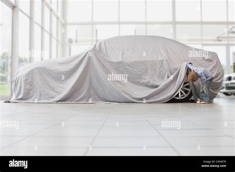 Boy Peeking Under Cloth On Car Stock Photo Alamy