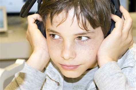 Portrait Of A Sweet Young Boy Listening To Music On Headphones Stock
