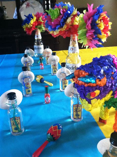 A Table Topped With Bottles And Flowers On Top Of A Blue Table Cloth