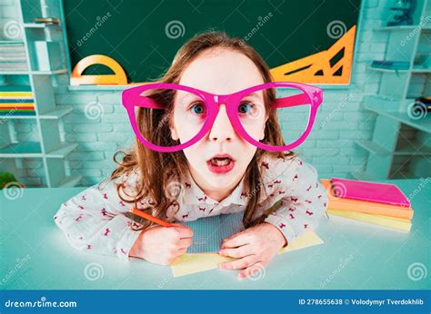 Funny Geek Surprised Child School Girl With Fun Glasses In Classroom