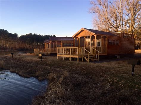 The classic log cabin great room includes a soaring cathedral ceiling, an open floor plan, and a massive stone fireplace. Starkville, Mississippi Lodging | Starkville KOA