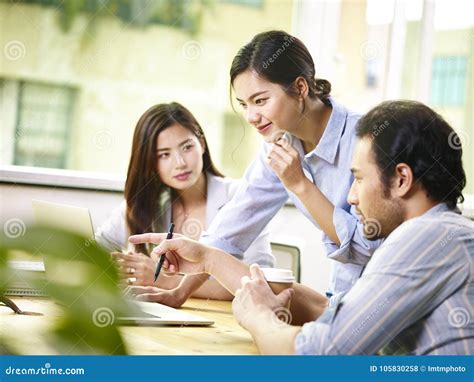 Asian Team Of Business People Working Together In Office Stock Photo