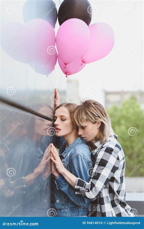 Sensual Lesbian Couple Embracing And Holding Air Balloons Outdoors