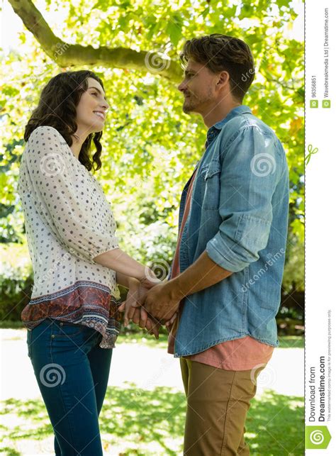 romantic couple looking face to face while holding hands in garden stock image image of