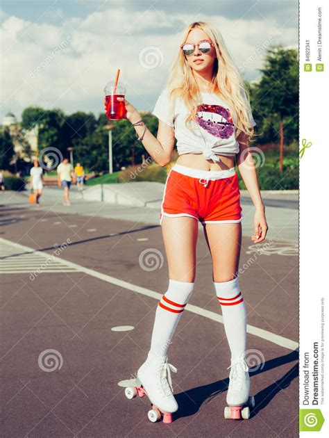 Beautiful Blonde Girl Posing On A Vintage Roller Skates In Pink Shorts