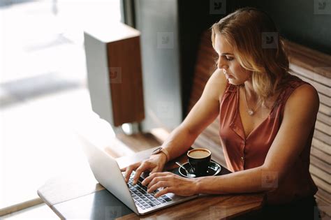 Woman Working On A Laptop Computer At A Coffee Shop Stock Photo 140545