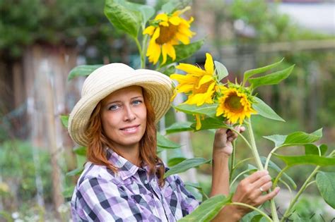 Premium Photo Woman With Sunflowers In The Garden
