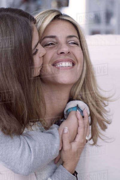Girl Kissing Mothers Cheek Stock Photo Dissolve