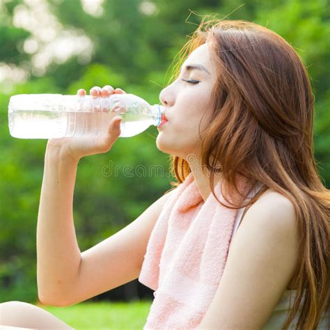 Woman Sitting Tired And Drinking Water After Exercise Stock Photo