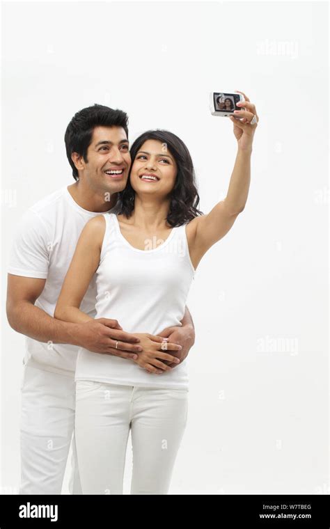 Young Couple Taking Picture Of Themselves With Digital Camera Stock
