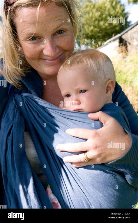 Woman Carrying A Baby In A Baby Sling Stock Photo Alamy