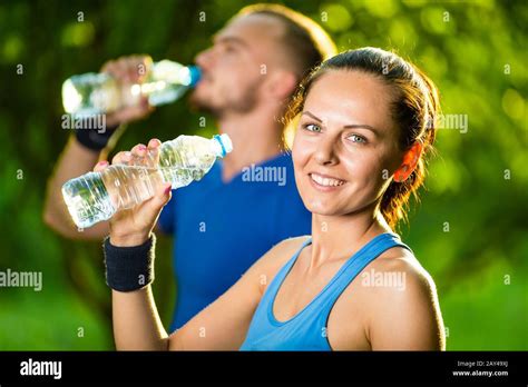 Man And Woman Drinking Water From Bottle After Fitness Sport Exercise