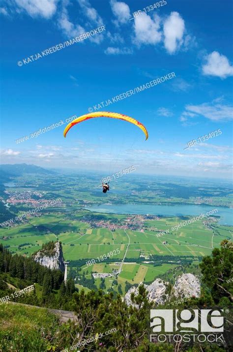 Paraglider On Tegelberg Mountain With A View Over Forggensee Lake