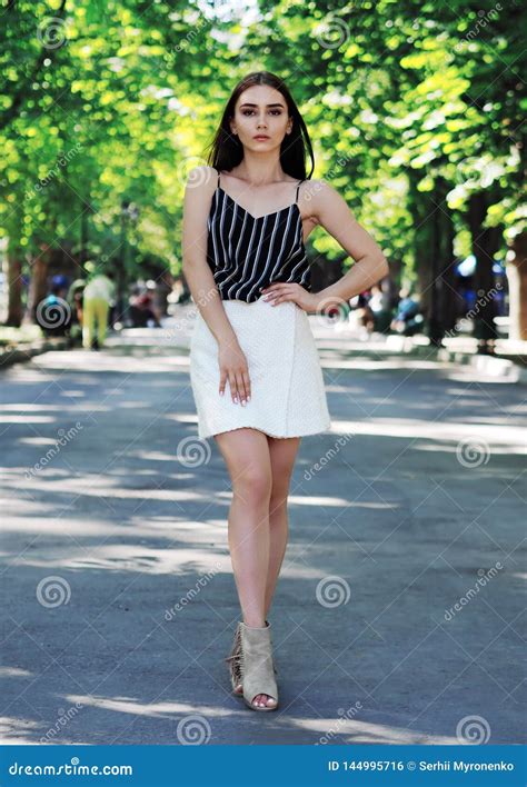 Young Girl Model Posing At The Park With Green Trees Stock Photo