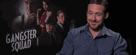 A Man Sitting In Front Of A Movie Poster On A Black Background With The Words Gangster Squad