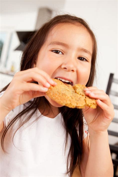 Young Girl Eating Cookie stock image. Image of enjoymant - 22020601
