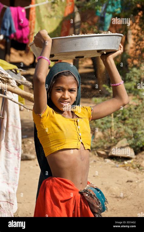 Girl Of Adivasi Tribe Winnowing Beans In Village Near Poshina Gujarat