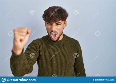 Arab Man With Beard Standing Over Blue Background Angry And Mad Raising