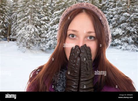 Young Woman With Gloves And Cap Freezing In Winter In A Forest With