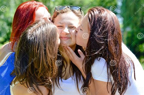 4 Beautiful Cute Girls Friends Having Fun Kissing Each Other Happy Smiling In The Summer Garden