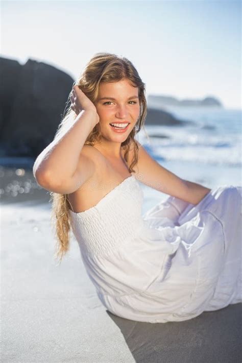 Beautiful Smiling Blonde In Sundress Sitting On The Beach Stock Photo