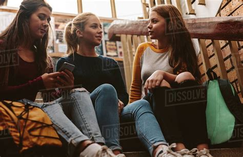 Group Of Three Girls Sitting On The Stairs And Chatting Group Of High