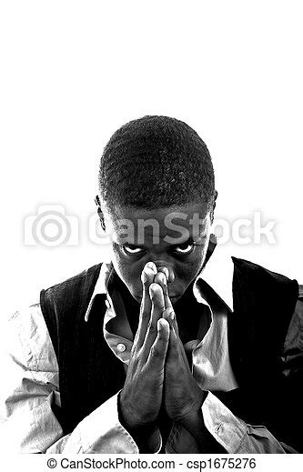 Young Black Man Praying A Young Black Man Dressed In Grey And Black