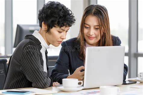 Businesswomen Asian And Caucasian Sitting In Office And Talking