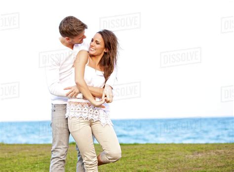 Portrait Of A Romantic Young Couple Enjoying Themselves By The Beach