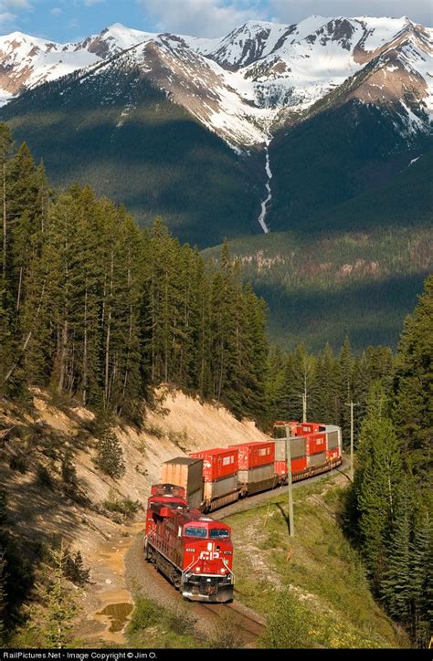 A Train Traveling Through The Mountains With Snow Covered Mountains In