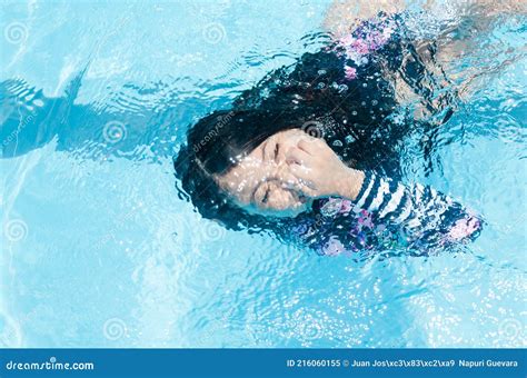 La Chica De La Piscina Nadando Bajo El Agua Sonriendo Y Sosteniendo Su