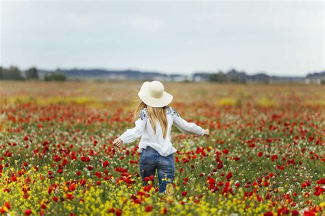 Woman Walking In A Flower Field Stock Photo