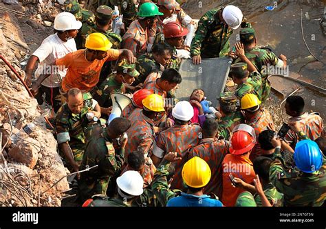 Rescuers Carry A Survivor Pulled Out From The Rubble Of A Building That Collapsed In Savar Near