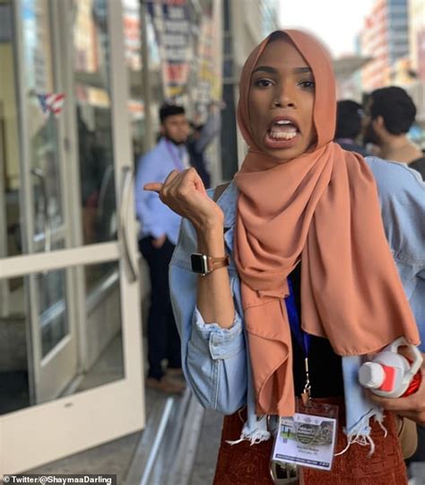 Smiling Woman In Hijab Flashing Peace Sign In Front Of Anti Muslim