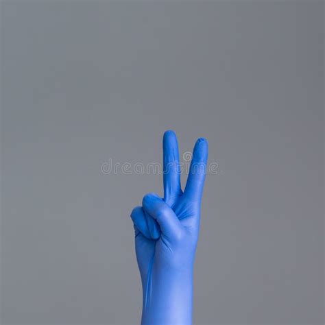 Hand In Surgical Glove Shows Two Fingers On Neutral Background Stock