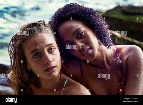 Two Gorgeous Girls Play Each Other Under A Small Waterfall At The Sea