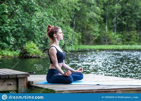 Meditation By Young Yogi Girl On The Pier Of A Beautiful Lake The