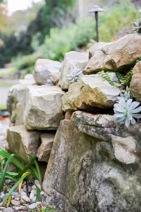 Technically, the elongate pile of stone (left) from which the laid wall (right) is being built qualifies as a stone wall (class). How to Build a Boulder Retaining Wall | how-tos | DIY