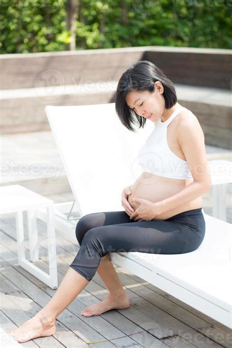 mujer joven asiática embarazada relajarse en el parque Foto de
