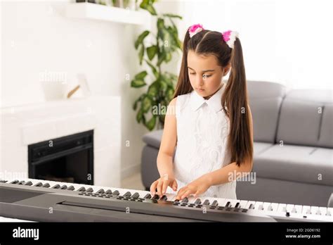 Beautiful Girl Sings While Playing On An Electronic Piano Stock Photo