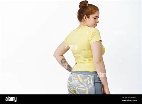 Rear View Of Redhead Chubby Woman Doing Workout Shot From Behind Standing Over White