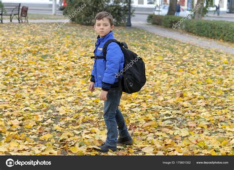 Boy Goes To School With A Large Knapsack Across The Lawn Stock Photo By