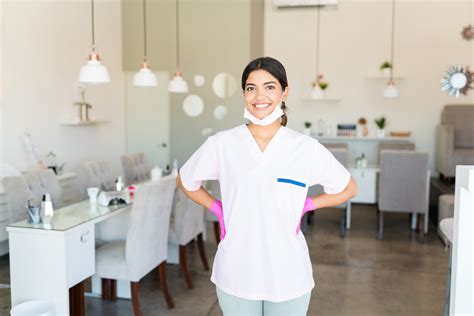 Self Assured Salon Worker Smiling In Uniform Spaclinic