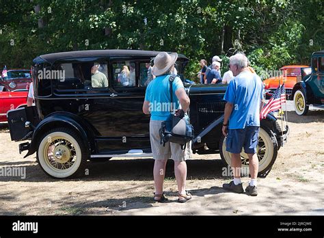Looking over a restored antique Ford at an antique auto parade and show