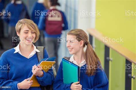 Two Smiling Female Students Wearing School Uniforms Walking Through