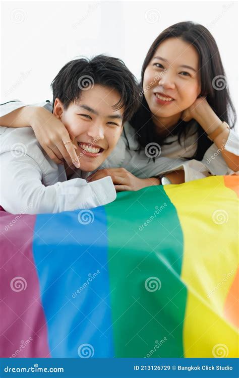 Lgbtq Couple Lovers A Handsome Girl As A Man Or Femme Girl Laying On A Bed With The Rainbow