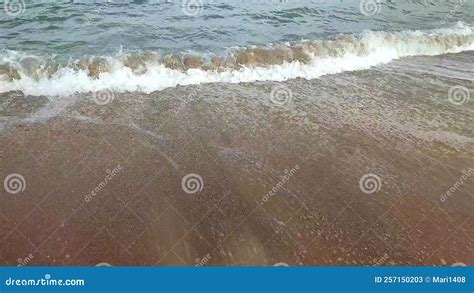 Sea Waves With White Foam Roll On The Sandy Beach Of The Seashore Close