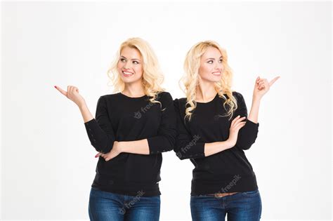Premium Photo Portrait Of A Smiling Sisters Twins Pointing Fingers Away Isolated On A White