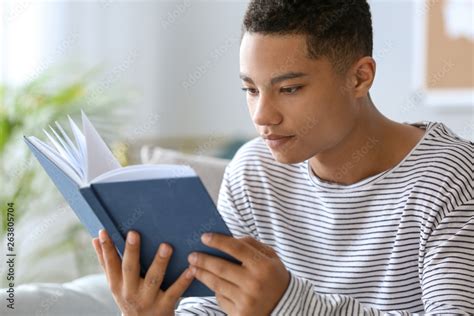 African American Teenage Boy Reading Book At Home Stock Foto Adobe Stock